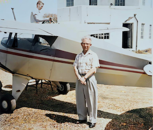 William J. Dumes with his plane<br>